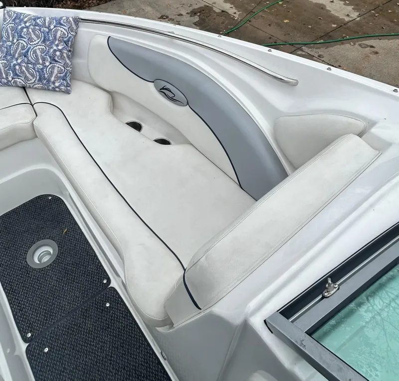 Slide: The Image of 2015 Rinker Captiva 276 BR boat interior with white seating and decorative pillow. - 13