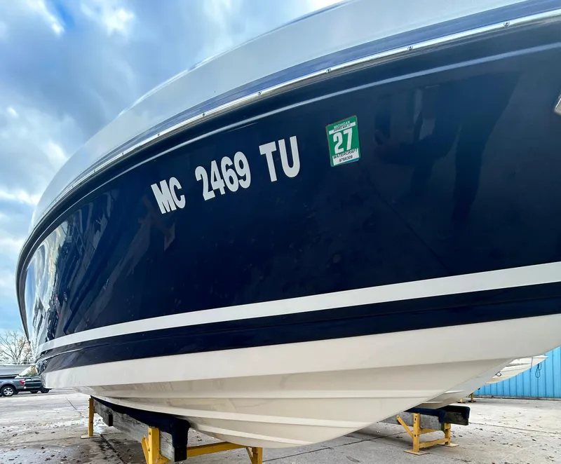Slide: The Image of 2015 Rinker Captiva 276 BR boat on stands, blue hull, registration MC 2469 TU. - 2