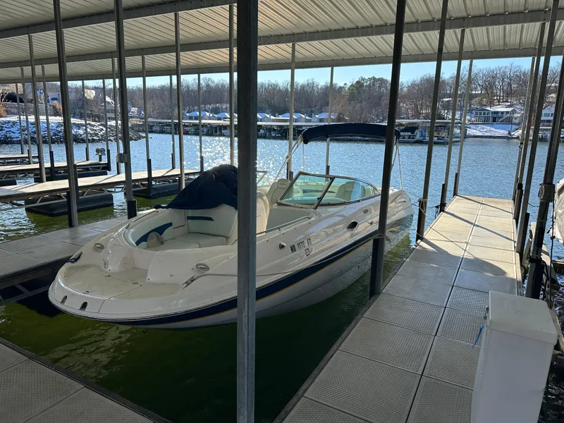 The Image of 2002 Chaparral 263 Sunesta boat docked in a marina under a covered slip. - 1