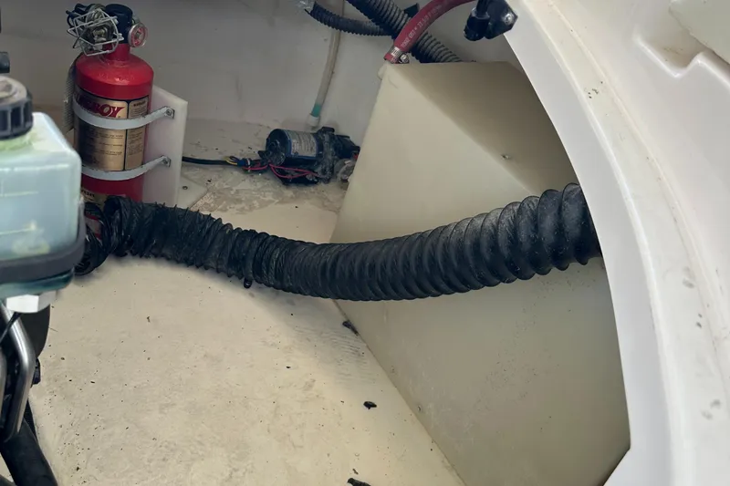 Slide: The Image of Engine compartment of a 2002 Chaparral 263 Sunesta boat with fire extinguisher and hoses. - 11