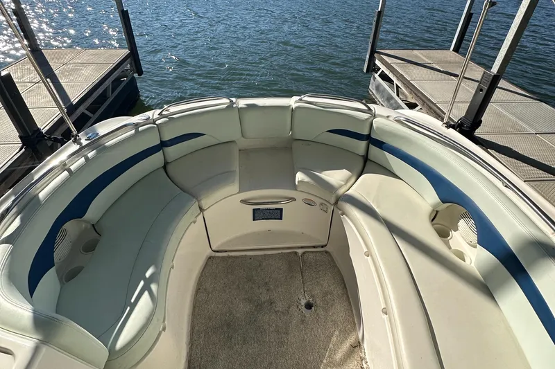 Slide: The Image of 2002 Chaparral 263 Sunesta boat interior with white and blue seating at dock. - 12
