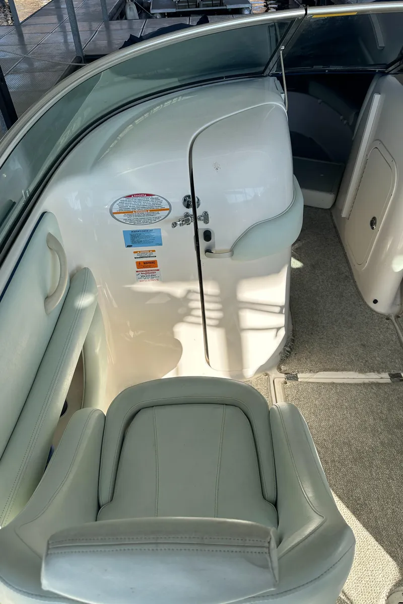 Slide: The Image of 2002 Chaparral 263 Sunesta boat interior with seating and cabin door. - 16