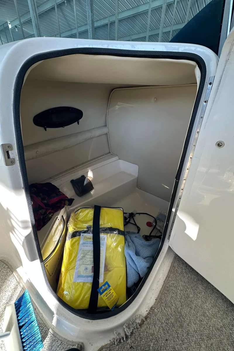 Slide: The Image of Storage compartment in 2002 Chaparral 263 Sunesta boat with life jacket and gear. - 18