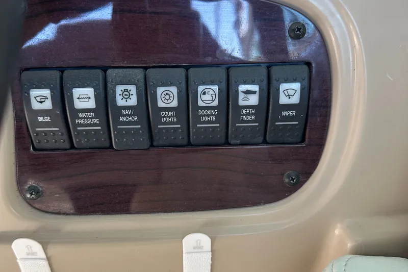 Slide: The Image of Control panel of a 2002 Chaparral 263 Sunesta boat with labeled switches. - 21