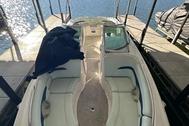 Slide: The Image of 2002 Chaparral 263 Sunesta boat interior with seating, docked by the water. - 23