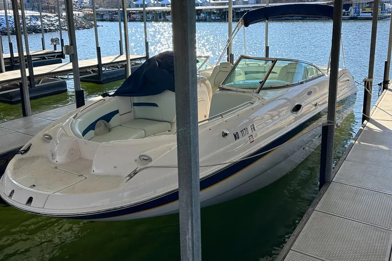 Slide: The Image of 2002 Chaparral 263 Sunesta boat docked in a marina, featuring a sleek white design. - 27