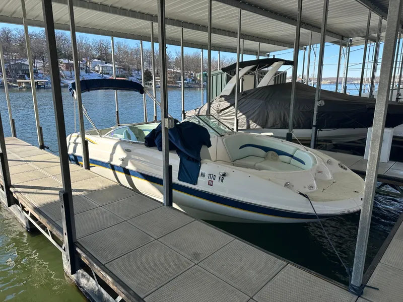 Slide: The Image of 2002 Chaparral 263 Sunesta boat docked in a marina under a covered slip. - 3