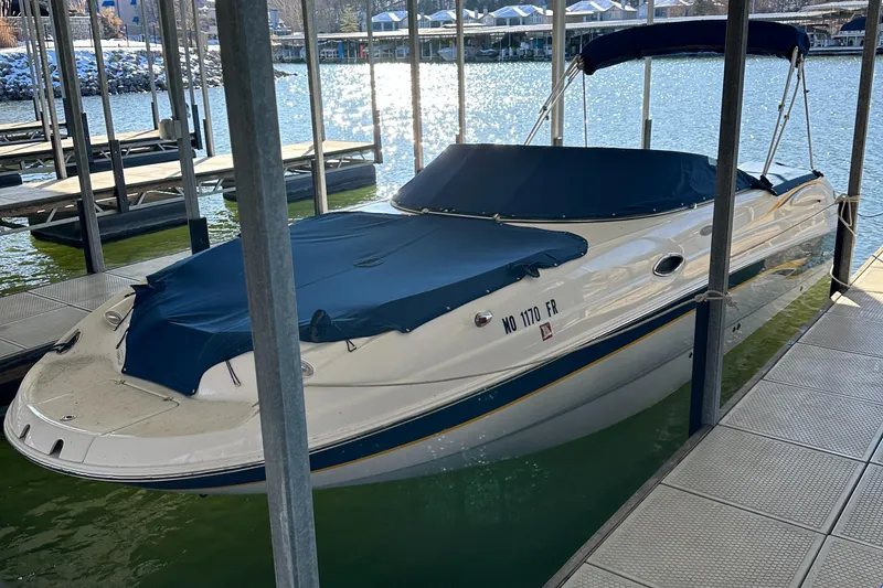 Slide: The Image of 2002 Chaparral 263 Sunesta boat docked with blue covers in a marina. - 5