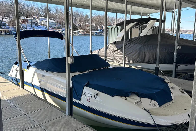 Slide: The Image of 2002 Chaparral 263 Sunesta boat docked with blue covers in a marina. - 7
