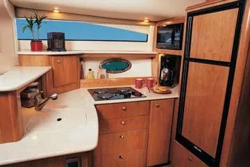 Slide: The Image of 2004 Meridian 459 Motoryacht docked at night, warmly lit interior, serene waterfront setting. - 17