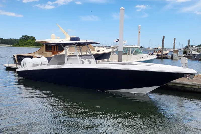 The Image of 2022 Fountain 38 SC boat docked at marina under clear blue sky. - 0