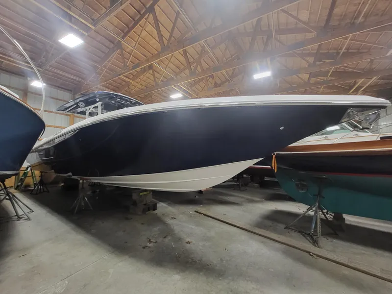 Slide: The Image of 2022 Fountain 38 SC boat in a wooden warehouse, side view. - 2