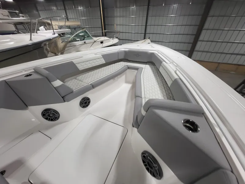 Slide: The Image of 2022 Fountain 38 SC boat interior with gray seating and speakers in a storage facility. - 25