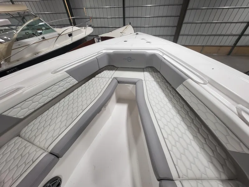 Slide: The Image of 2022 Fountain 38 SC boat interior with white and gray seating in a storage facility. - 26