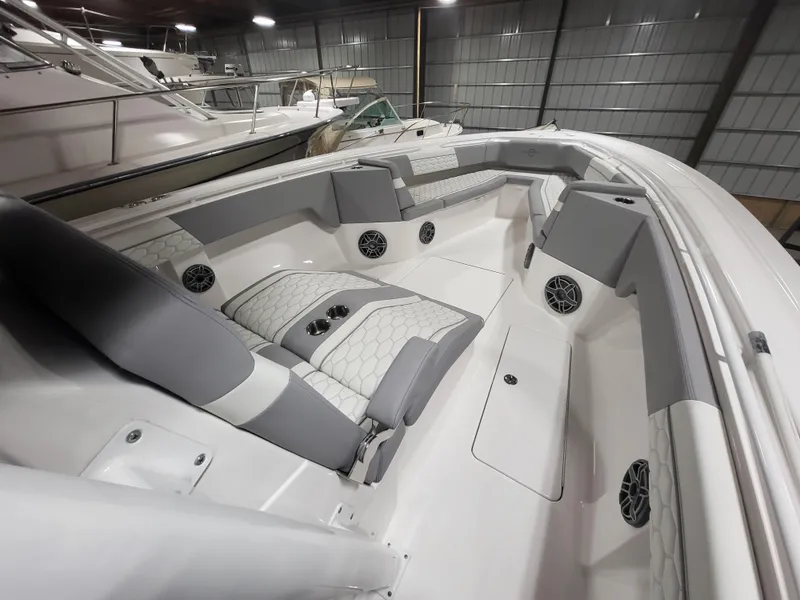 Slide: The Image of 2022 Fountain 38 SC boat interior with gray and white seating in a storage facility. - 28