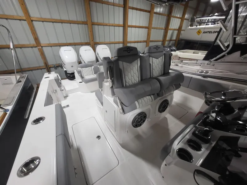 Slide: The Image of 2022 Fountain 38 SC boat interior with plush seating and modern controls in a storage facility. - 30