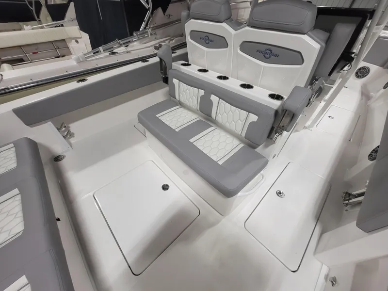Slide: The Image of 2022 Fountain 38 SC boat interior with gray and white seating and cup holders. - 40