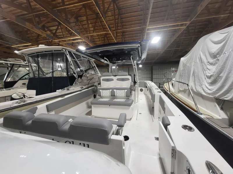 Slide: The Image of 2022 Fountain 38 SC boat in indoor storage, surrounded by other covered boats. - 41