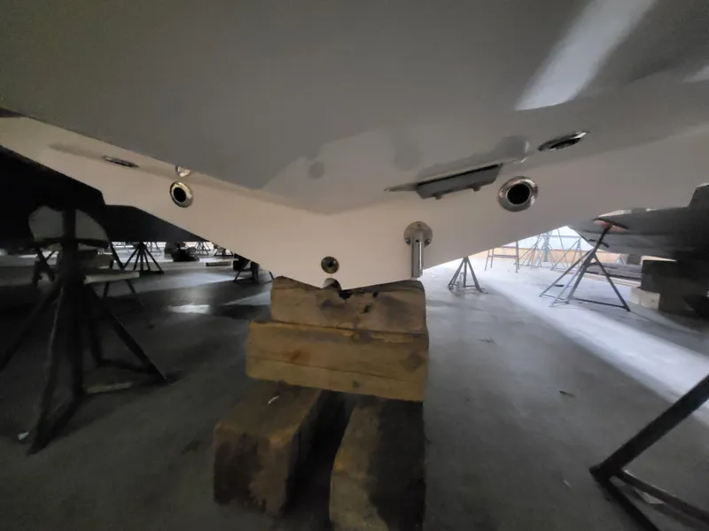 Slide: The Image of 2022 Fountain 38 SC boat hull on wooden blocks in storage. - 6