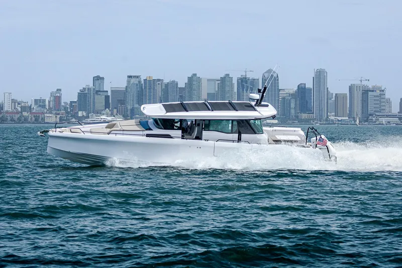 The Image of 2025 Axopar 45 boat cruising on water with city skyline in background. - 0