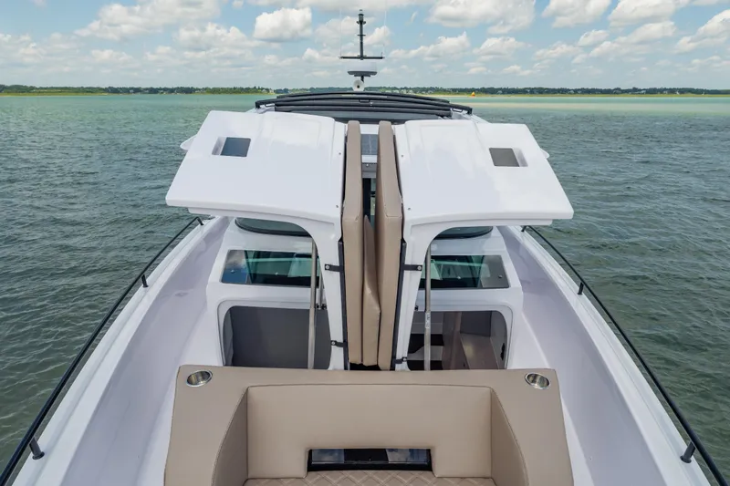 Slide: The Image of 2025 Axopar 45 XC Cross Cabin on water, showcasing open cabin design and seating. - 19