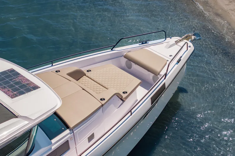 Slide: The Image of 2025 Axopar 45 XC Cross Cabin boat with sunbathing area, docked by the shore. - 16