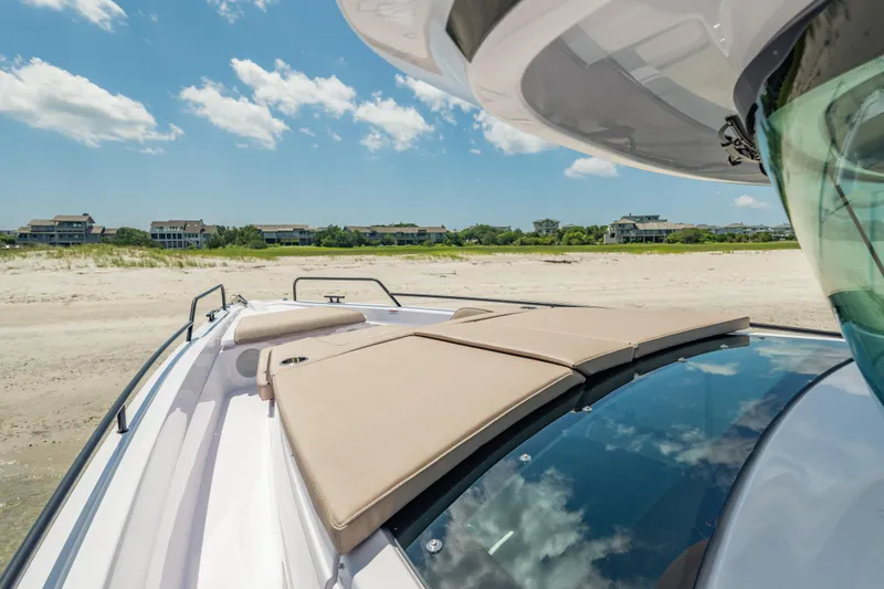 Slide: The Image of 2025 Axopar 45 XC Cross Cabin boat on sandy beach with clear blue sky. - 21