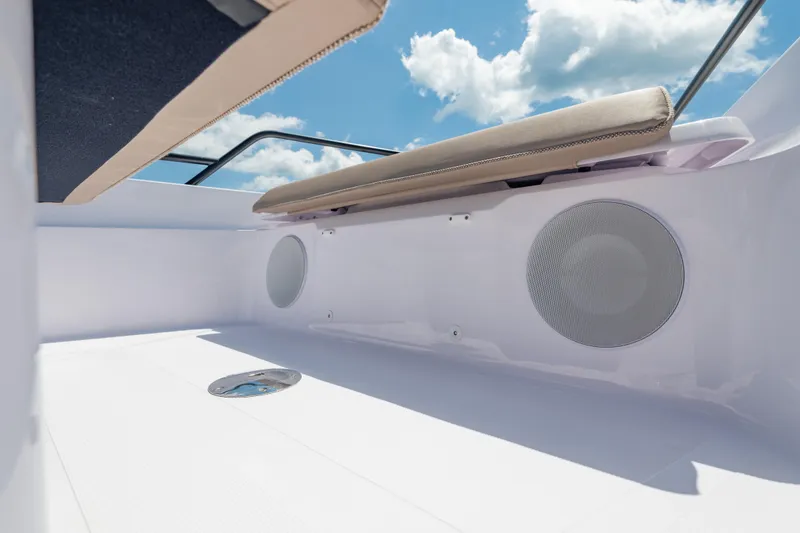 Slide: The Image of 2025 Axopar 45 XC Cross Cabin interior with cushioned seating and built-in speakers under a blue sky. - 26