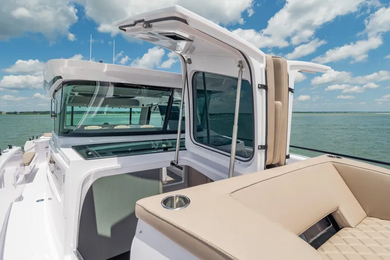 Slide: The Image of 2025 Axopar 45 XC Cross Cabin boat with open cabin doors on a sunny day. - 20