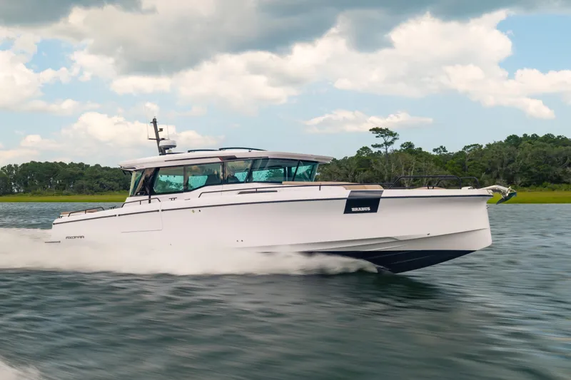 The Image of 2025 Axopar 45 XC Cross Cabin cruising on water under a cloudy sky. - 0