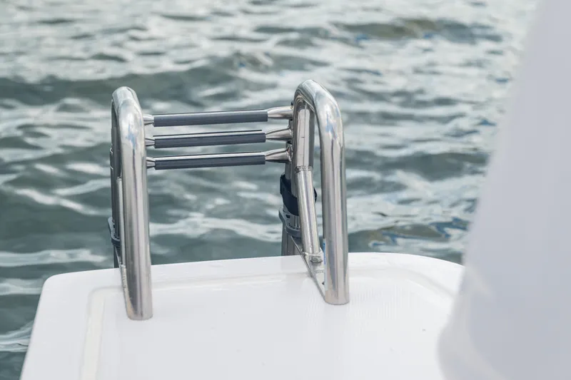 Slide: The Image of Stainless steel ladder on 2025 Axopar 45 XC Cross Cabin boat by the water. - 28