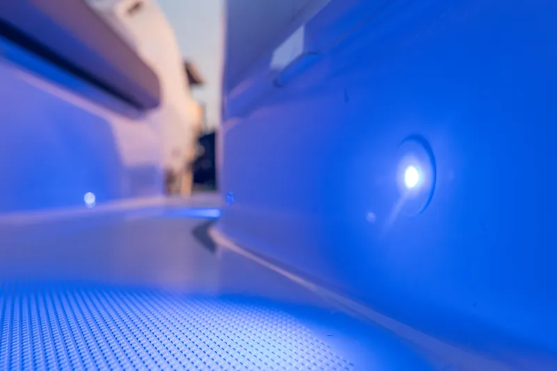 Slide: The Image of 2025 Axopar 45 XC Cross Cabin interior with ambient blue lighting. - 25