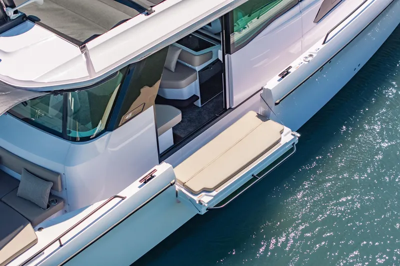 Slide: The Image of 2025 Axopar 45 XC Cross Cabin boat with open side deck on water. - 18