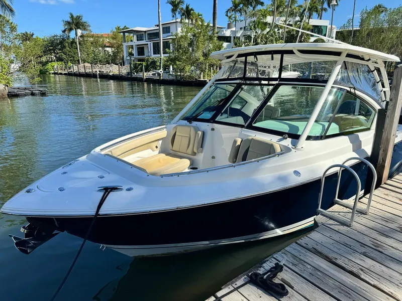 The Image of 2020 Pursuit 266 boat docked by a scenic waterfront. - 0