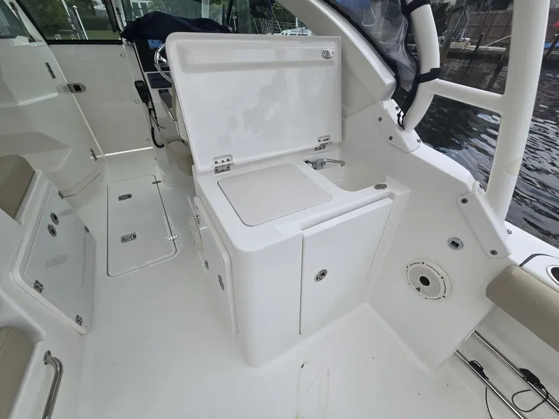 Slide: The Image of 2020 Pursuit 266 boat interior with open storage compartment and seating area. - 10