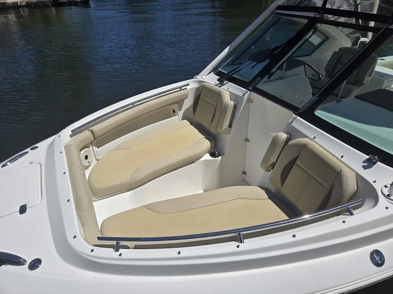 Slide: The Image of 2020 Pursuit 266 boat with beige seating, docked on calm water. - 11
