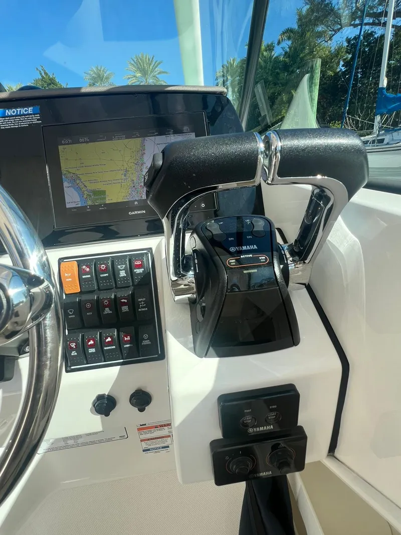 Slide: The Image of 2020 Pursuit 266 boat dashboard with controls and navigation display. - 19