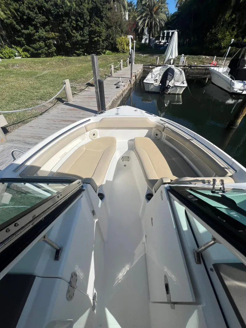 Slide: The Image of 2020 Pursuit 266 boat docked by lush greenery and calm water. - 22