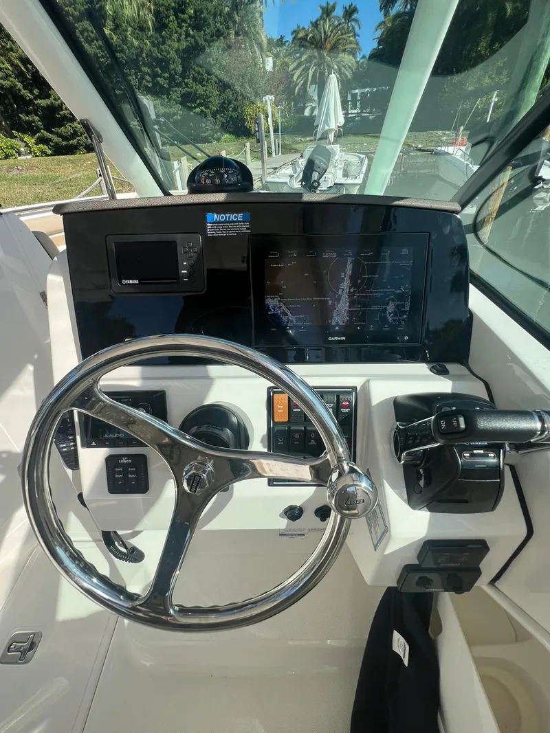 Slide: The Image of 2020 Pursuit 266 boat dashboard with steering wheel and control panel. - 25