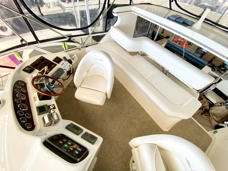 Slide: The Image of 2001 Sea Ray 380 Aft Cabin helm with white seating and control panel. - 12