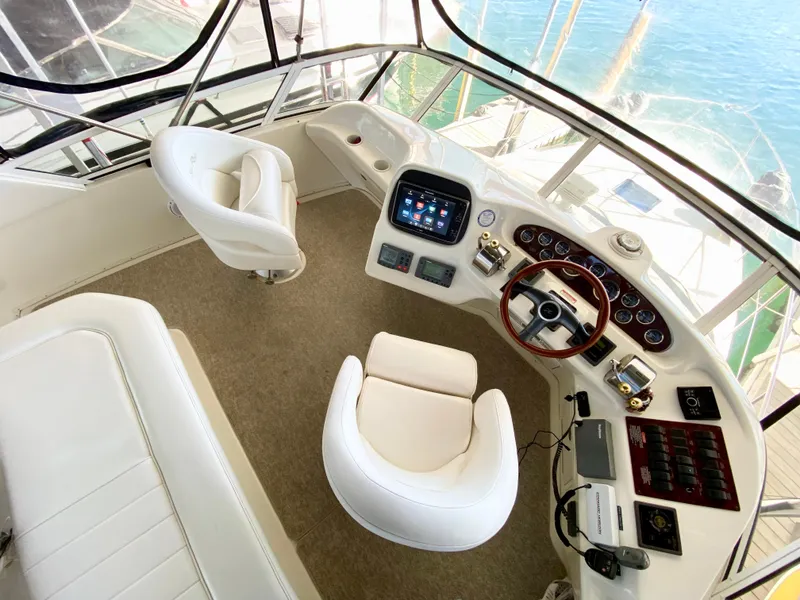 Slide: The Image of 2001 Sea Ray 380 Aft Cabin helm with modern controls and plush seating. - 13