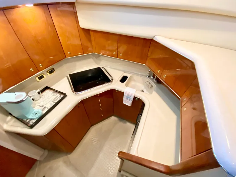 Slide: The Image of 2001 Sea Ray 380 Aft Cabin kitchen with wood cabinets and modern appliances. - 19