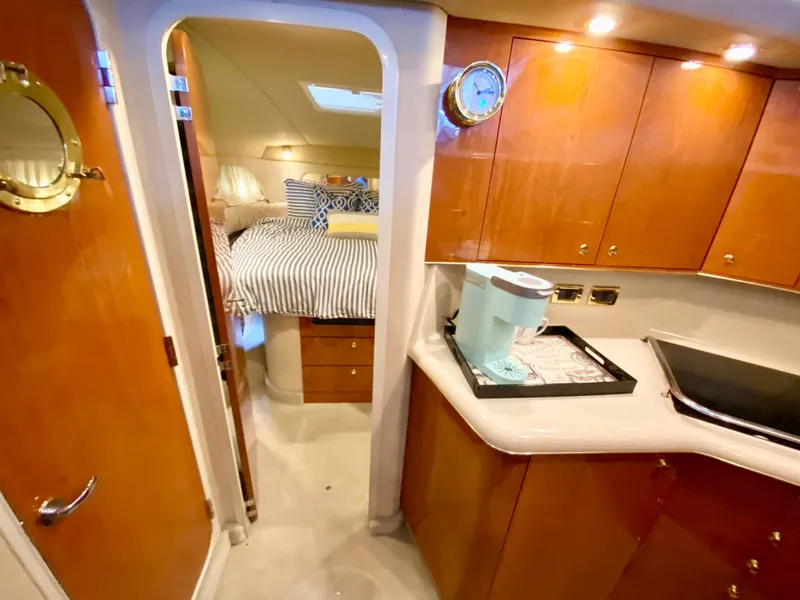 Slide: The Image of 2001 Sea Ray 380 Aft Cabin interior with kitchen and cozy bedroom. - 21