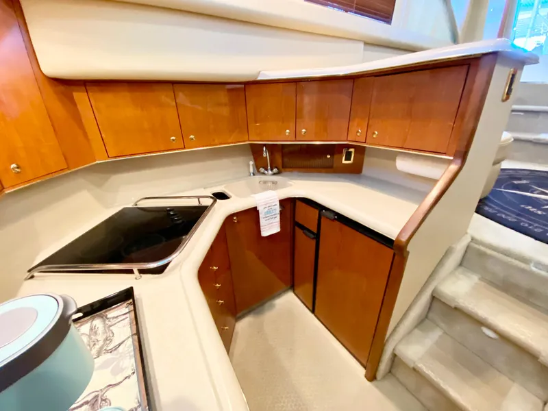 Slide: The Image of 2001 Sea Ray 380 Aft Cabin kitchen with wood cabinets and modern appliances. - 22