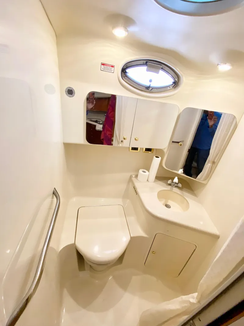 Slide: The Image of 2001 Sea Ray 380 Aft Cabin bathroom with sink, toilet, and mirror. - 23