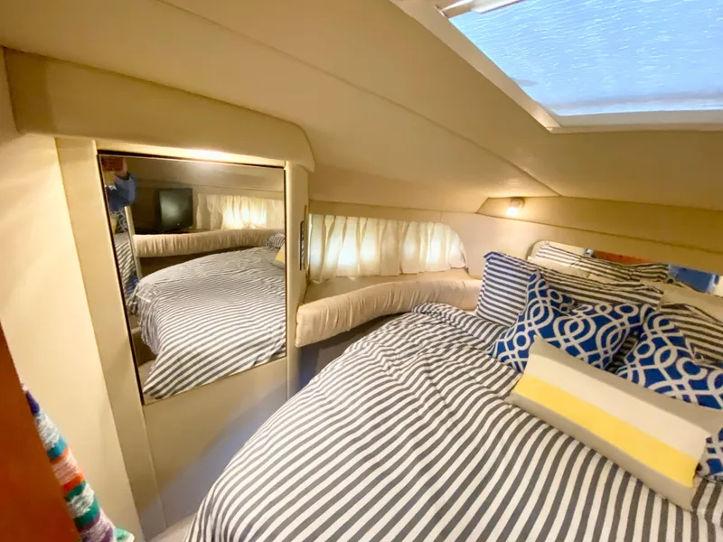 Slide: The Image of Cozy bedroom in 2001 Sea Ray 380 Aft Cabin with striped bedding and decorative pillows. - 27