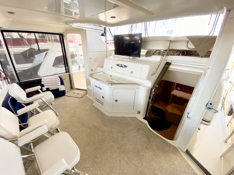Slide: The Image of 2001 Sea Ray 380 Aft Cabin interior with seating, TV, and storage cabinets. - 4