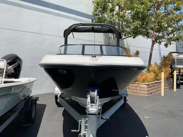 Slide: The Image of 2025 Bayliner VR4 Bowrider I/O on trailer, parked outdoors near trees. - 3