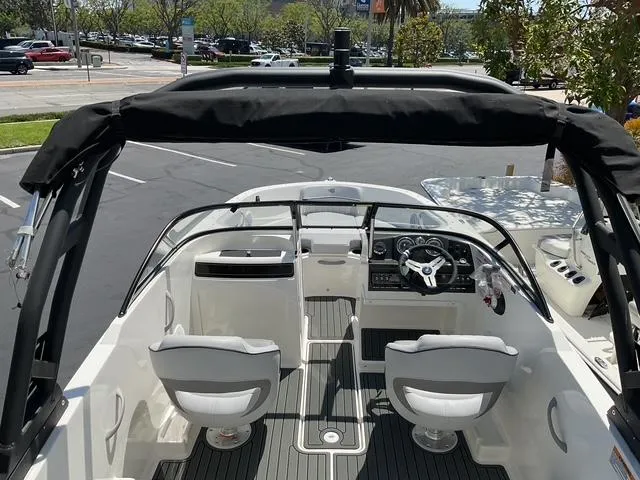 Slide: The Image of 2025 Bayliner VR4 Bowrider I/O interior with dual seats and steering wheel, parked outdoors. - 7