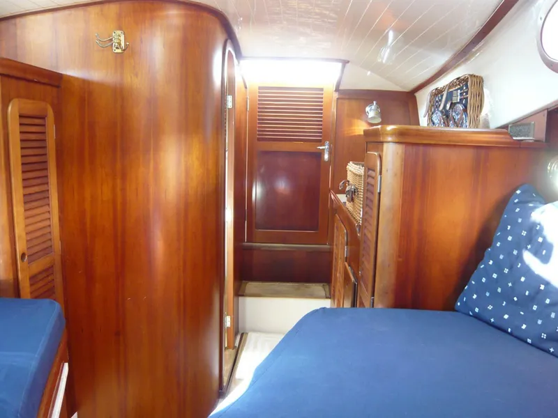 Slide: The Image of Interior of 1998 Hinckley 36 Classic yacht with wooden cabinetry and blue bedding. - 24